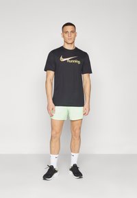 Nike Performance STRIDE - Sports shorts - vapor green/dark stucco/reflective silver