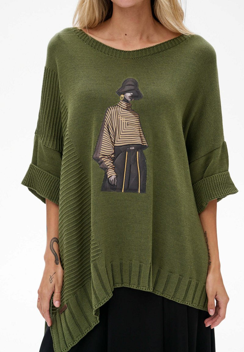 Oliwkowy sweter z dzianiny z oversize'owymi rękawami, z graficznym nadrukiem modelki w paskowanym ubiorze z przodu. Ribbowany detal u dołu.