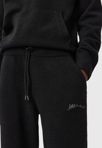 Schwarzes Fleece-Loungewear-Set mit einem Hoodie mit Fronttasche und Jogginghose mit elastischem Bund und gesticktem Logodetail.
