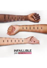 Tre armar visar olika hudtonsfärger med en variation från ljus till mörk. Varje färgprov är märkt med ett nummer. Produkttexten "Infallible 24H More Than Concealer" syns nedanför.