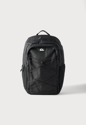 Sac à dos Quiksilver noir avec cordon élastique à l'avant, poignée supérieure, poches latérales et compartiments zippés sur fond blanc uni.