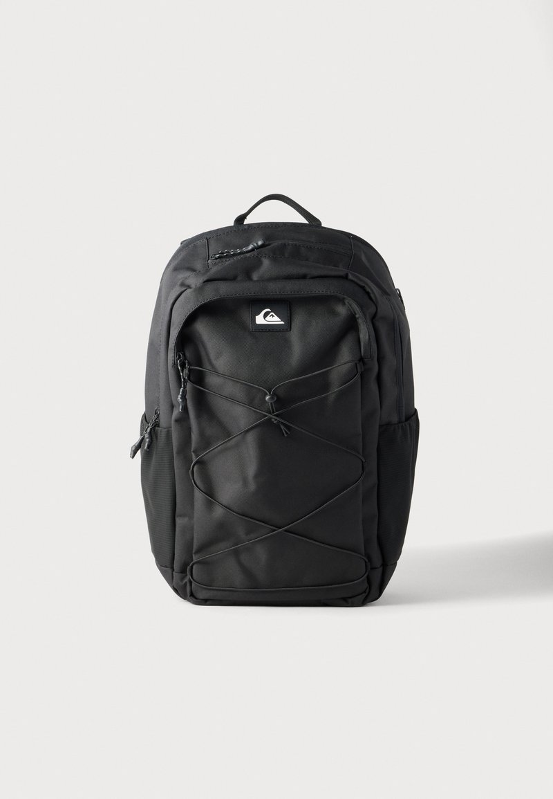 Μαύρο σακίδιο πλάτης Quiksilver με ελαστικό κορδόνι μπροστά, κορυφαία λαβή, πλαϊνές τσέπες και διαμερίσματα με φερμουάρ σε λευκό φόντο.