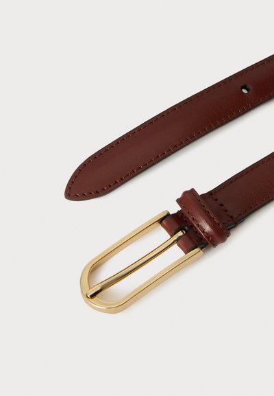 Ceinture en cuir marron avec coutures visibles et boucle rectangulaire dorée sur un fond clair.