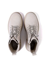 Stivali alla caviglia beige realizzati in suede texturizzato con lacci grigi, zip laterale e suola in gomma robusta. Fodera interna liscia per il comfort.