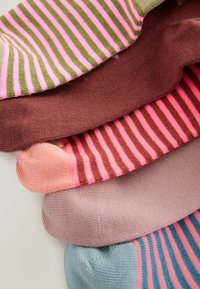 Gestreifte Socken in verschiedenen Farben: grün und rosa, braun, rosa, hellrosa und blau mit dunkelblauen Streifen, die eine glatte Textur zeigen.