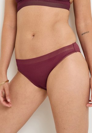 Bas de bikini en filet bordeaux avec une ceinture lisse, présentant un motif en chevrons subtil et un tissu extensible et respirant.