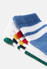 Conjunto de calcetines de algodón tipo crew en azul, blanco, rojo, amarillo y verde. Presenta patrones a rayas y puños acanalados. Textura de punto suave.