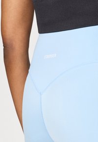 Απαλά μπλε κολάν με λεία υφή, που διαθέτουν το λευκό λογότυπο "STRONGER" και καμπύλες ραφές. Υλικό jersey με εφαρμοστή σχεδίαση.