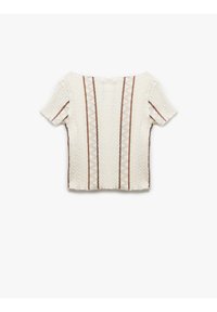Biały, fakturowany top z krótkim rękawem z pionowymi brązowymi paskami w zygzakowate wzory na środku, okrągłym dekoltem i luźnym krojem.