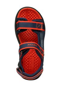 Námořnické a oranžové sportovní sandály s nastavitelnými popruhy, texturovanou gumovou podrážkou a polstrovanými tečkami, označené "GEOX WATER FRIENDLY."