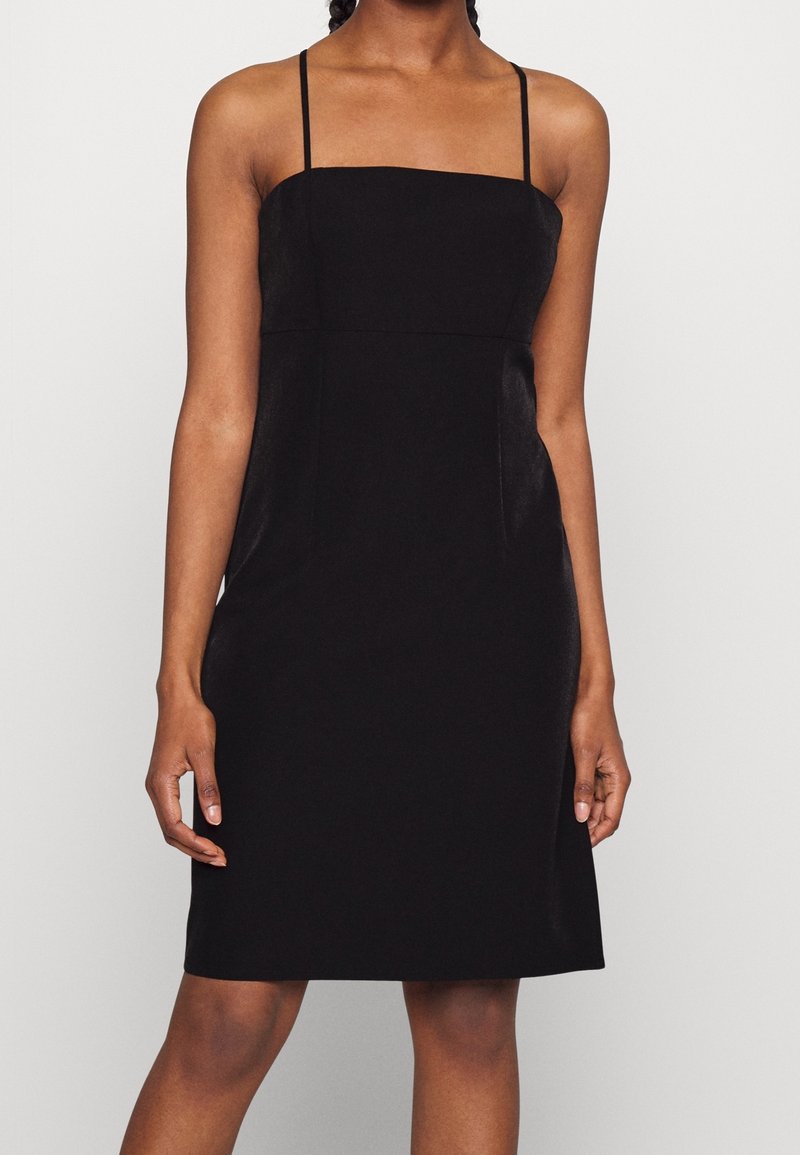 Black fitted dress with thin straps, square neckline, and a smooth, matte texture. Knee-length with a streamlined silhouette and no patterns.