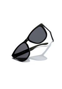Ochelari de soare negri cu o formă geometrică de tip cat-eye, lentile întunecate și finisaj mat. Brațe subțiri și drepte, cu detalii subtile. Umbră proiectată dedesubt.