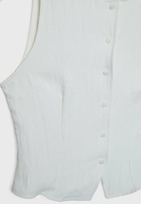 Witte mouwloze top van lichtgewicht stof, met een knoopsluiting aan de voorkant, een zak aan de linkerkant en een rechte zoom.