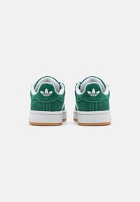Baskets en suede vert avec doublure en mesh blanche, bout rond et semelle en caoutchouc naturel. Présente un logo brodé sur le talon et des coutures contrastées.
