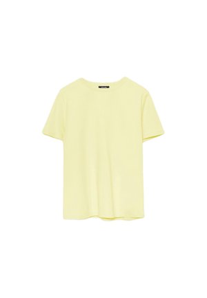 Maglietta in cotone a maniche corte di colore giallo chiaro, collo tondo, vista frontale, con una piccola etichetta nera all'interno del colletto.
