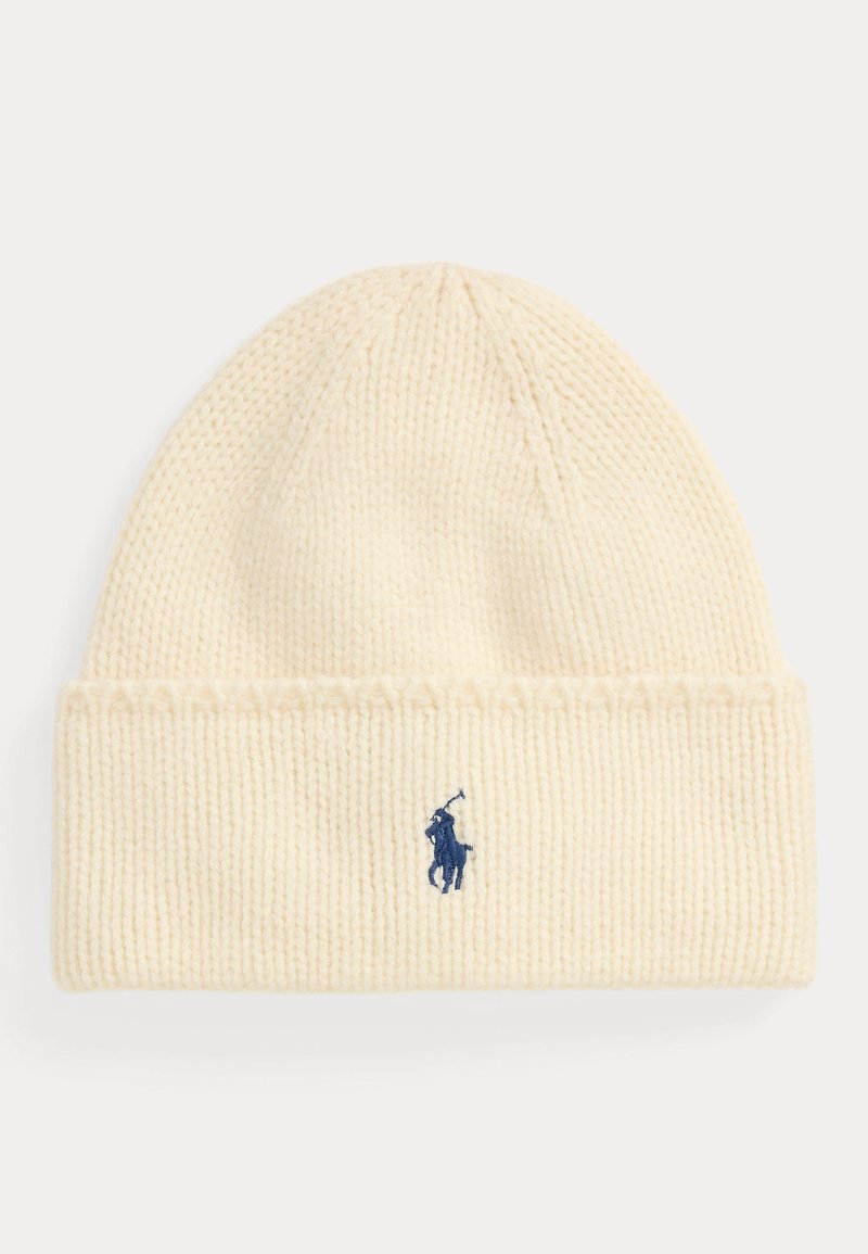 Pletená čepice v krémově bílé barvě, s žebrovaným lemem a námořnicky modrým vyšitým logem s motivem koně a jezdce. Měkká textura, zaoblený vršek.