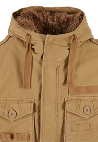 Chaqueta con capucha en color arena, con forro de piel sintética, que cuenta con dos bolsillos de parche y un zipper central, acentuada con cordones marrones y una etiqueta.