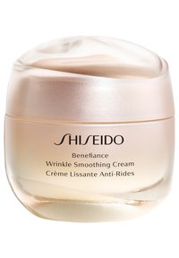 Shiseido Benefiance Wrinkle Smoothing Cream i en gjennomsiktig gullkrukke med et jevnt, avrundet lokk, har preget tekst og en blank overflate.