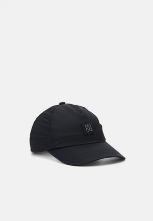 Zwarte honkbalpet met een gebogen klep en een vierkant patch-logo met het woord "HUGO" op het voorpaneel.