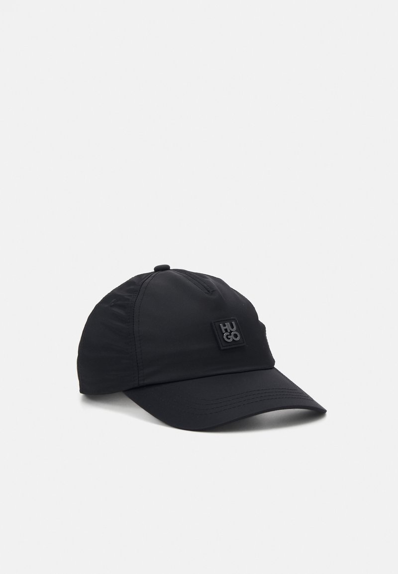 Casquette de baseball noire avec une visière incurvée et un patch carré affichant le mot "HUGO" sur le panneau avant.
