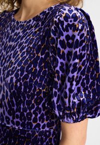 Lila Leopard-Print-Kleid mit Samttextur, Puffärmeln und einem glatten, abgerundeten Ausschnitt. Auffällig durch seine lebhaften Farben und das Muster.
