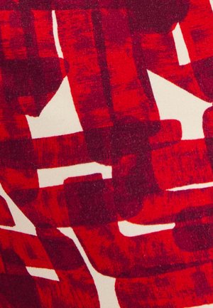 Tissu abstrait présentant de vives motifs de coups de pinceau rouges sur un fond clair, avec une apparence texturée et des formes contrastées.