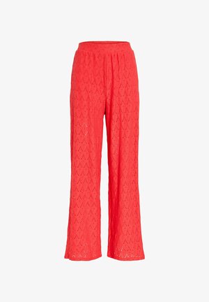 Rdeče široke hlače z vzorcem čipke z luknjicami in elastičnim pasom, prikazane na beli podlagi.