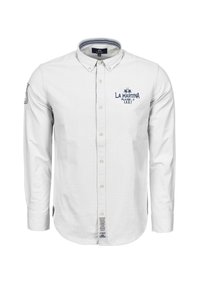 Bílá košile s dlouhým rukávem a zapín�áním na knoflíky, vyrobená z bavlny; má límec, vyšitou modrou značku a jemný kostkovaný vzor. Na lemu je etiketa.