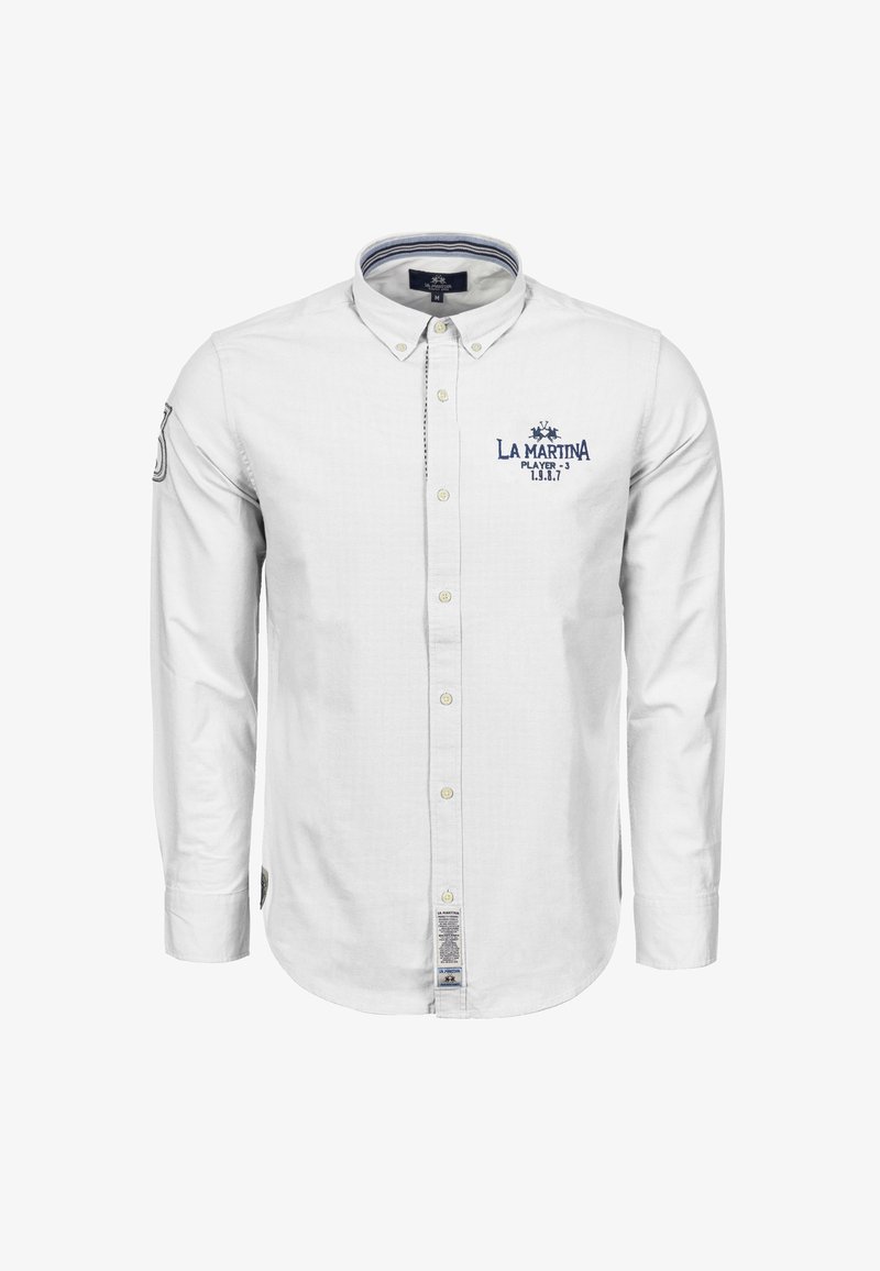 Biała bawełniana koszula na długi rękaw, zapinana na guziki; posiada kołnierzyk, niebieskie haftowane logo oraz subtelny wzór w drobną kratkę. Na dole znajduje się metka.