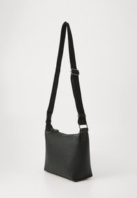 Borsa a tracolla nera in materiale sintetico con tracolla regolabile, forma rettangolare, superficie liscia e dettagli in metallo argentato.