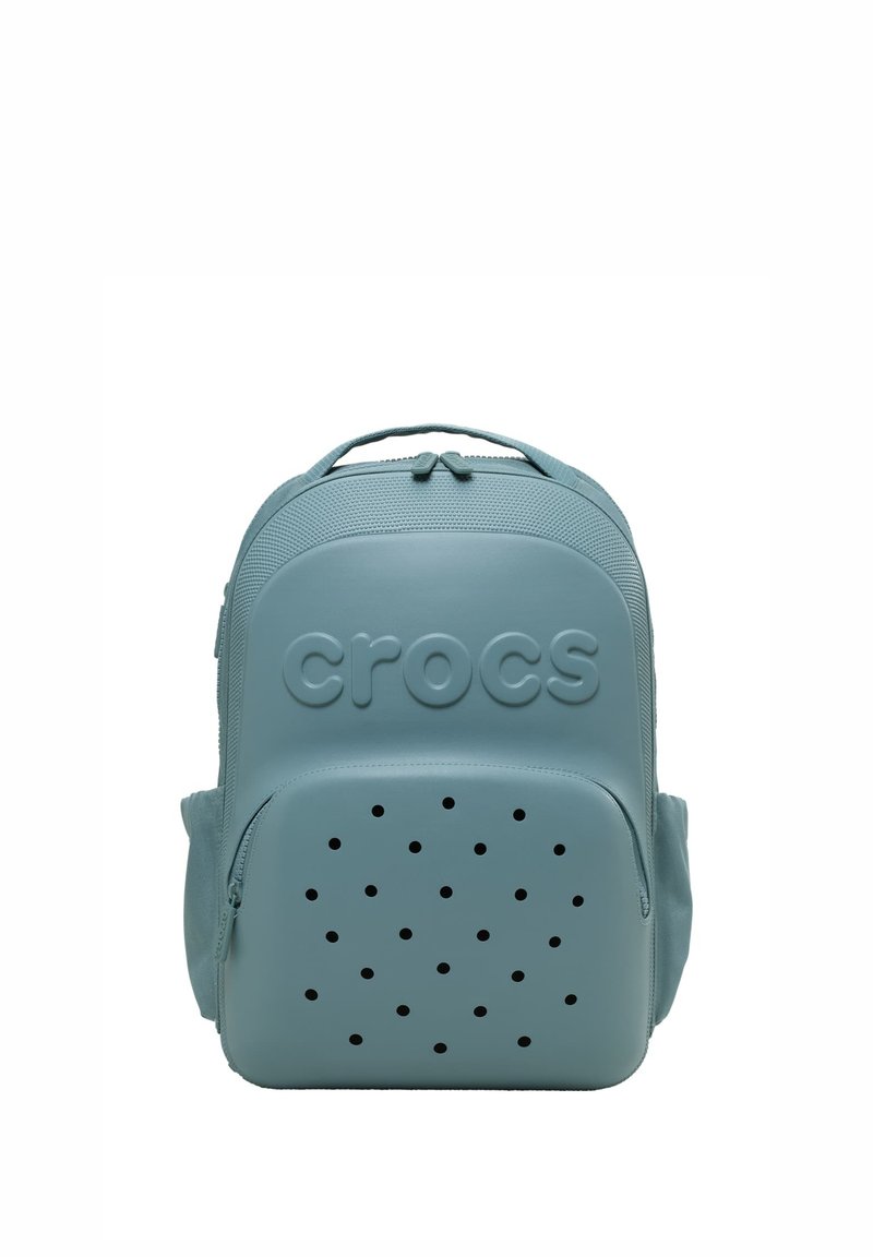 Jasnoniebieski plecak Crocs z teksturowanym wierzchem, perforowaną przednią kieszenią oraz wytłoczonym logo "crocs", zaprezentowany na białym tle.