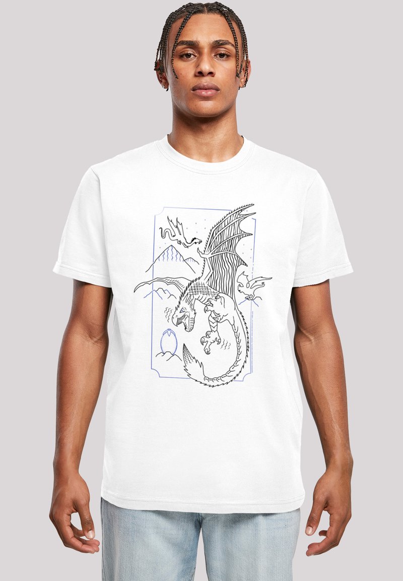 Camiseta blanca con un gráfico de dragón negro y azul que presenta montañas, un huevo y detalles de líneas intrincadas. Manga corta y cuello redondo.