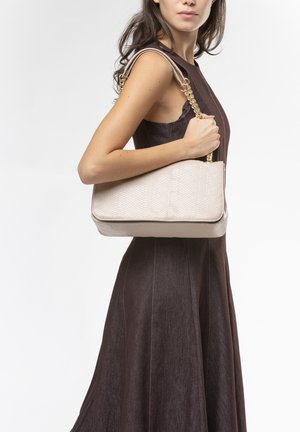 Borsa a tracolla in similpelle beige con motivo a rilievo effetto serpente, dotata di una catena dorata come tracolla e una forma strutturata. Indossata sulla spalla.