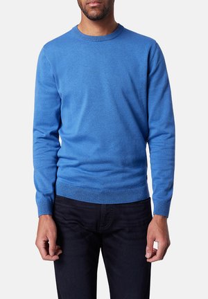 Blue long-sleeve sweater, round neck, made of soft fabric, features ribbed cuffs and hem, worn over dark pants, smooth texture.