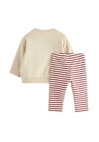 Beige sweatshirt with long sleeves and ribbed cuffs paired with red and white striped leggings, featuring an elastic waistband.