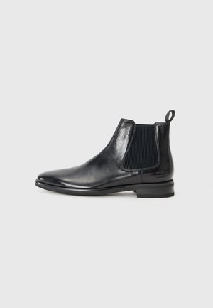Bota Chelsea de cuero negro con paneles elásticos en los laterales, puntera redondeada y tirador en la parte posterior. Textura suave con un diseño elegante.