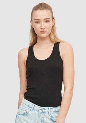 Top de tanque negro de canalé con escote redondo y tirantes anchos, combinado con pantalones cortos de mezclilla azul claro con cierre de botón.