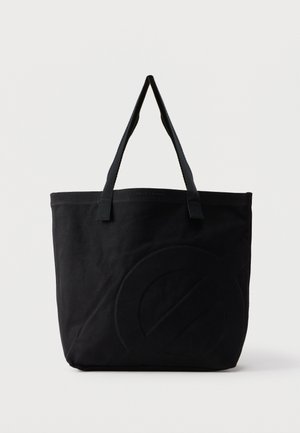 Sac fourre-tout en toile noire avec deux bandoulières et un motif circulaire discret en relief sur le devant.