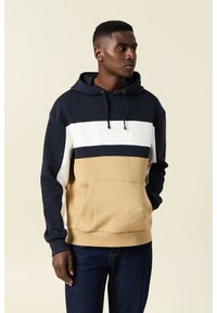 Felpa con cappuccio nei colori blu navy, bianco e beige. Presenta una tasca frontale, un cordoncino regolabile e un marchio testurizzato sul petto.