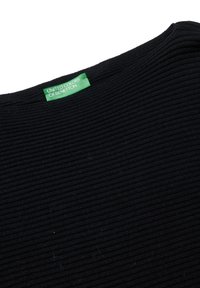 Czarna, prążkowana koszulka z okrągłym dekoltem. Metka z napisem "UNITED COLORS OF BENETTON" w białym kolorze na zielonym tle. Miękka tekstura.