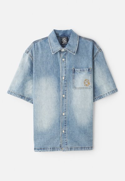 Lys blå denim kortermet skjorte med krage, frontlomme og subtil falming, med metallknapper og brodert design.