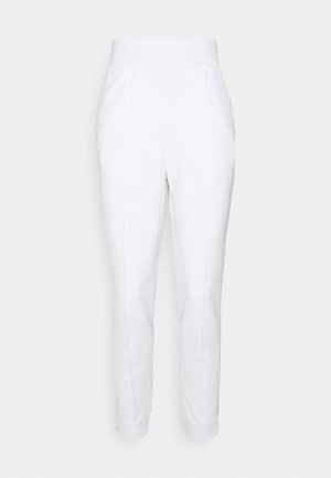 Pantalon blanc taille haute fuselé avec une large ceinture, coutures devant, poches latérales et fermetures éclair aux chevilles sur un fond uni.