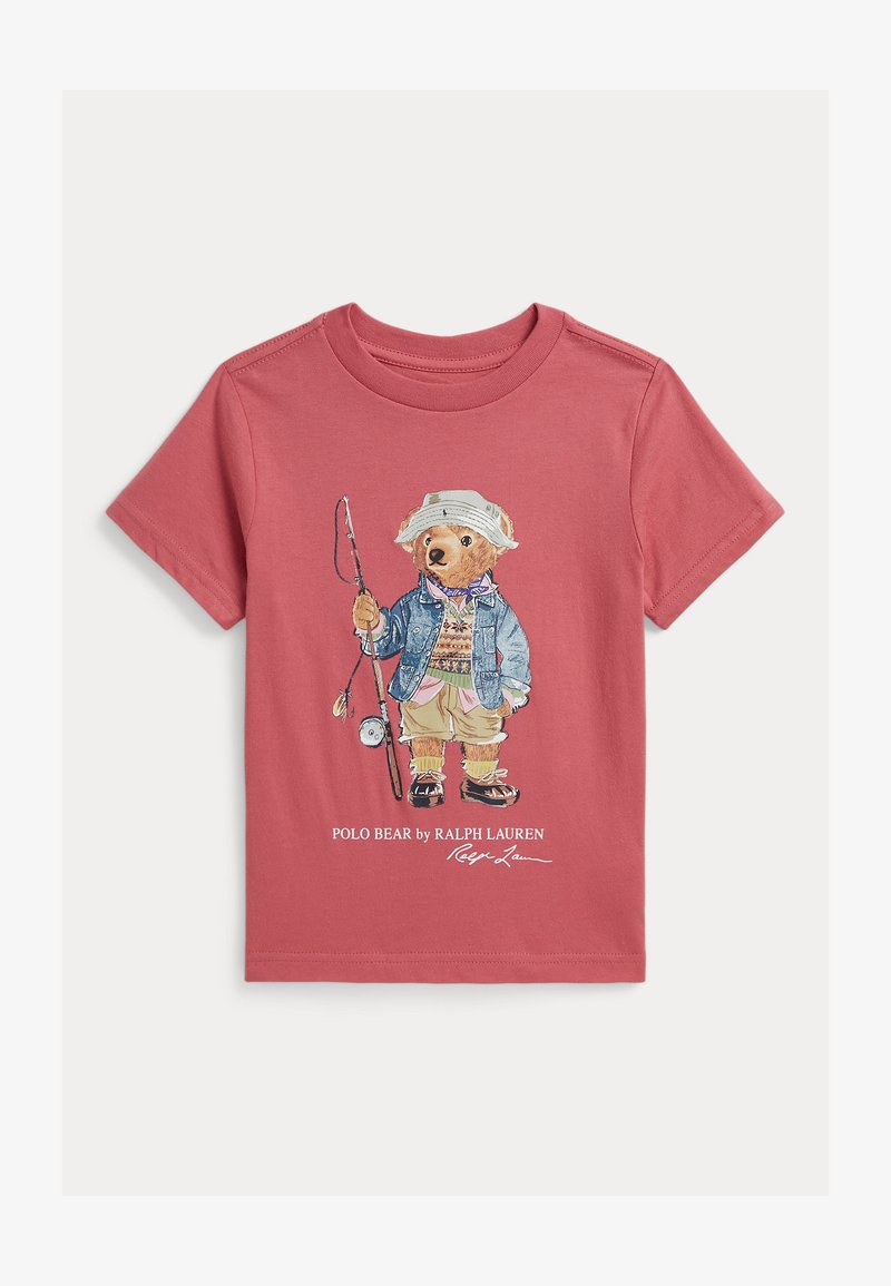 T-shirt rouge à manches courtes pour enfant avec un ours illustré en tenue de pêche tenant une canne à pêche, et le texte « Polo Bear by Ralph Lauren » en dessous.