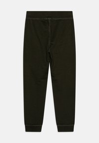 Leggings en coton vert foncé avec une taille élastique, design ajusté et rétrécissant vers la cheville. Texture simple et lisse.