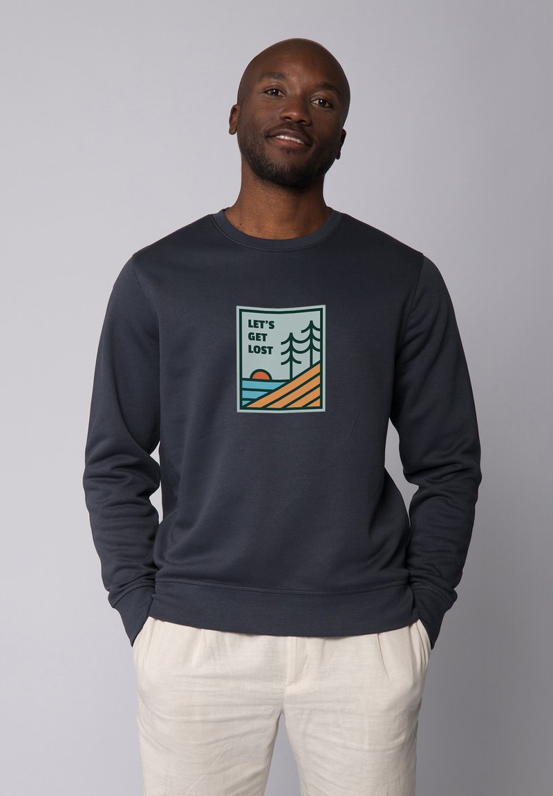 Marine sweatshirt met ronde hals, met een grafische print van bomen en een zonsondergang met de tekst "Laten we verdwalen." Zachte textuur.
