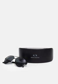 Ochelari de soare negri cu o formă rotundă și lentile întunecate. Însoțiți de un toc negru cu logo-ul "A|X ARMANI EXCHANGE" în alb.