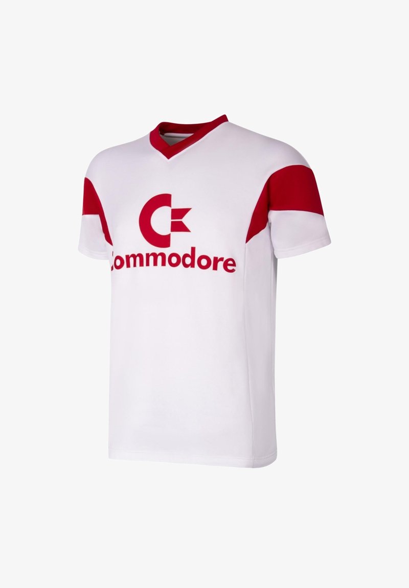 Weißes Trikot mit roten Akzenten, V-Ausschnitt und kurzen Ärmeln. Zeigt ein großes rotes "Commodore"-Logo auf der Vorderseite. Hergestellt aus weichem Material.