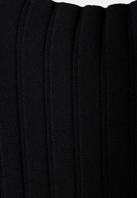 Gros plan d'un tissu en maille côtelée noire montrant des rayures texturées verticales et un motif tricoté.