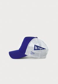 Lilla basebollkappe med solid front, netting bag, og broderet "LA Dodgers" logo. Har flad skygge og justerbar snapback lukning.