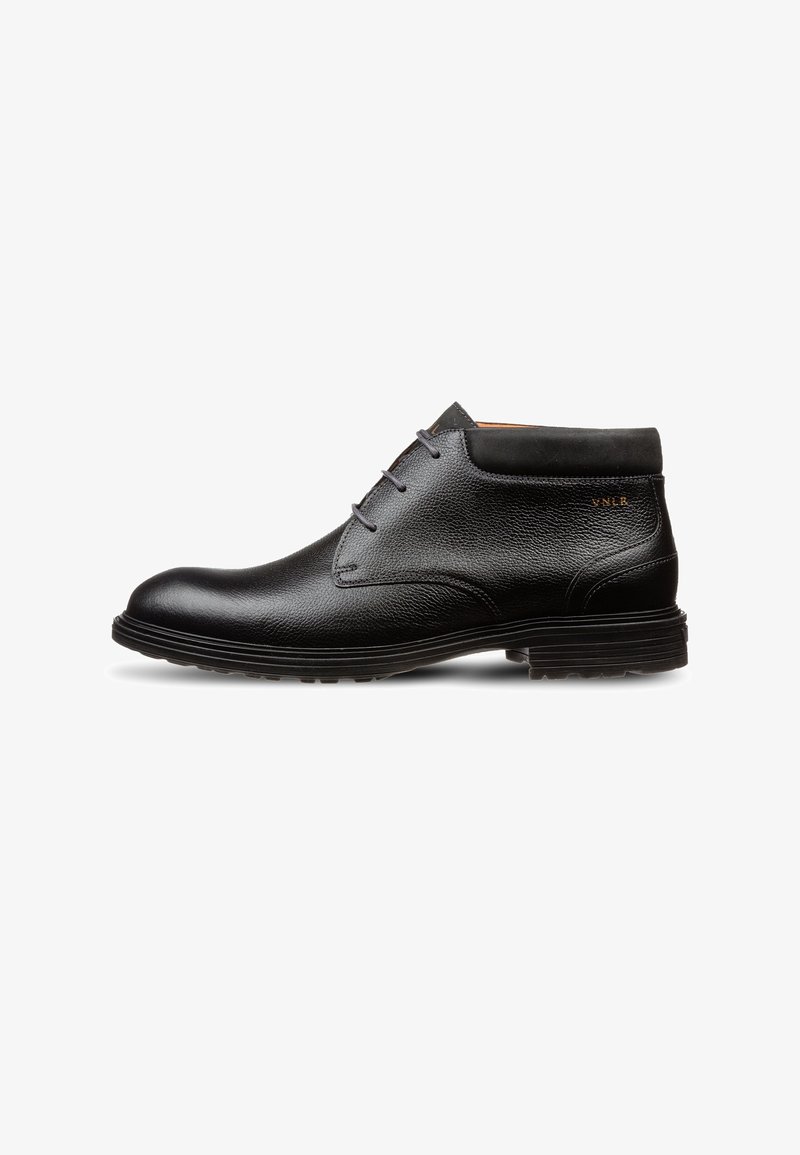 Bottine pour homme en cuir noir avec laçage avant, surface texturée, col rembourré et semelle en caoutchouc épaisse, vue de profil.